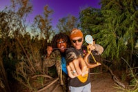 a man and a woman posing for a picture in the woods